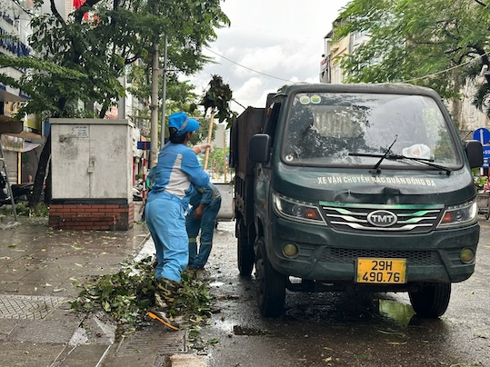 Các công nhân môi trường phải làm việc từ sáng sớm để khắc phục hậu quả của cơn bão số 3. Ảnh: Việt Anh. 