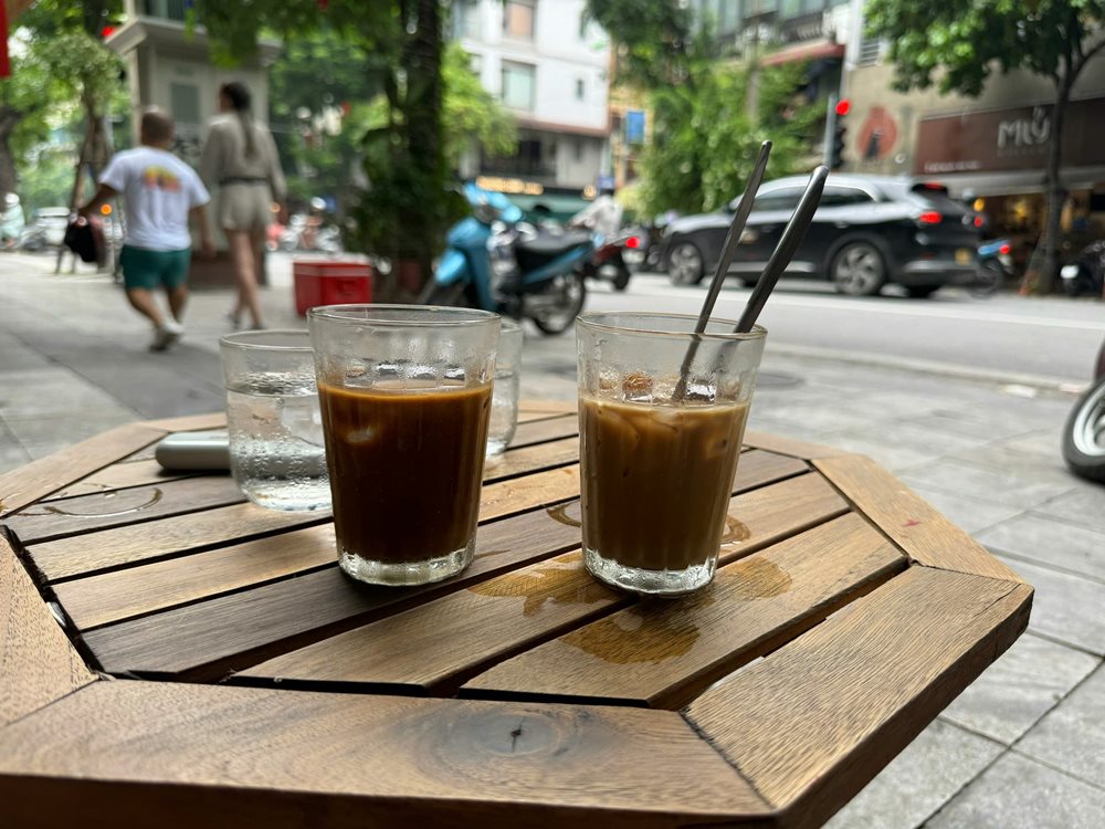 Du khách ngồi nhâm nhi cà phê vừa ngắm phố cổ Hà Nội đông đúc. Ảnh: Phương Anh
