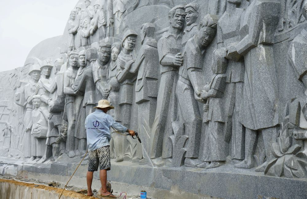 The workers hustled to grind and clean the statue. Photo: Quach Du