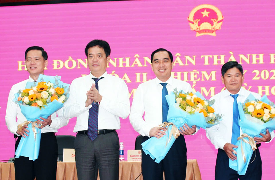 Ông Lê Quốc Anh (giữa) - Bí Thư Thành ủy Phú Quốc tặng hoa chúc mừng Tân Chủ tịch UBND TP Phú Quốc Trần Minh Khoa (bìa trái) và các nhân sự khác. Ảnh: Xuân Nhi