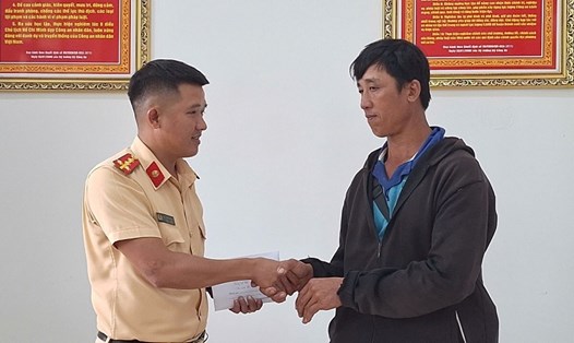 Đại úy Kiều Thanh Hùng (Phòng Cảnh sát giao thông, Công an tỉnh Đắk Lắk) trao trả lại tiền cho ông Phan Ngọc Hùng. Ảnh: Công an cung cấp