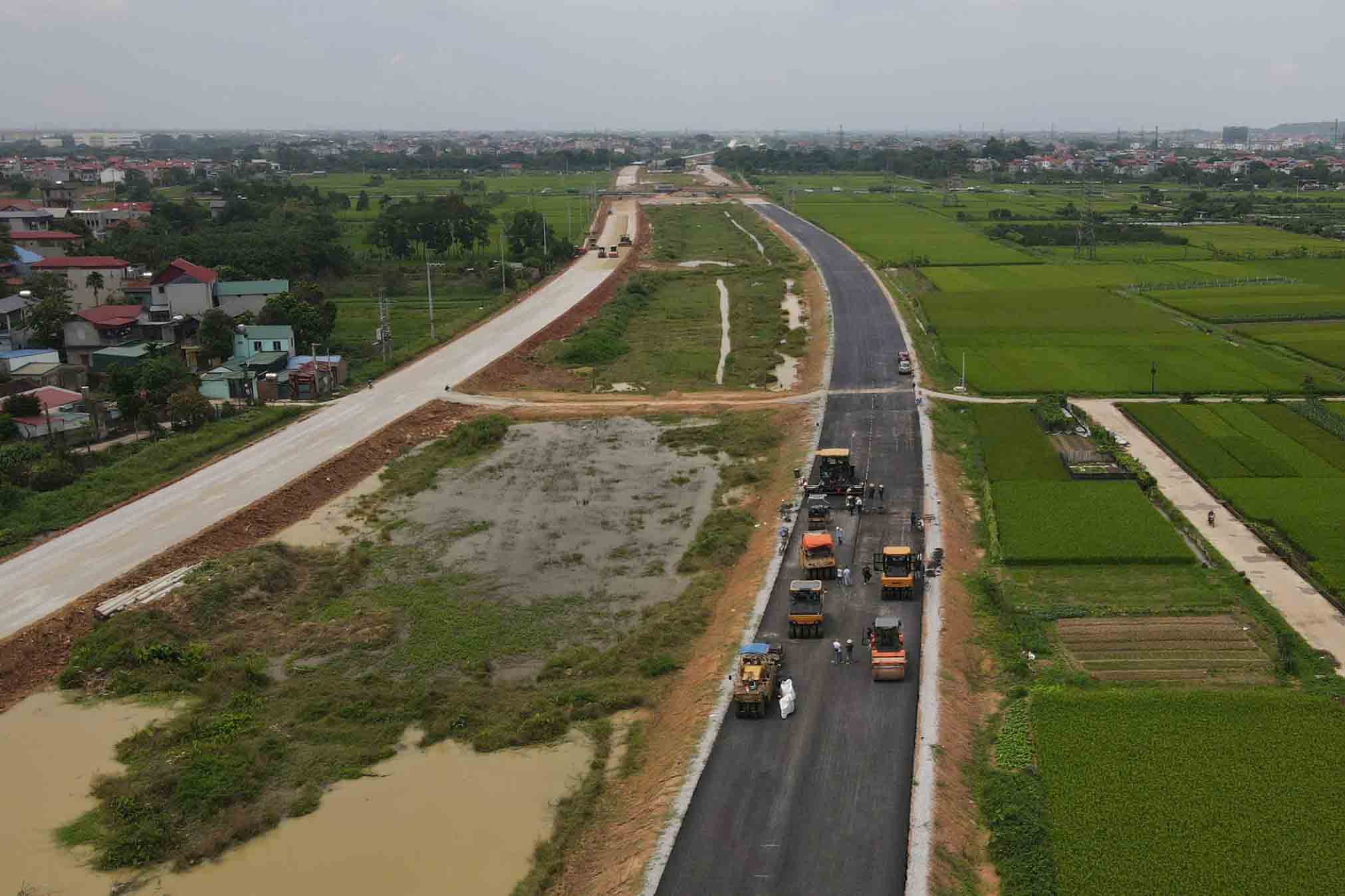 Đường song hành Vành đai 4 đoạn qua xã Tân Dân (huyện Sóc Sơn) đã được nhà thầu thảm những lớp nhựa đầu tiên. Ảnh: Hữu Chánh