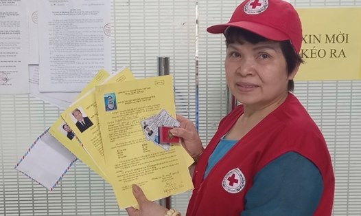 Bà Nguyễn Thị Xuân Hương - Hội Chữ thập đỏ quận Hoàn Kiếm, Hà Nội nhận thẻ đăng ký hiến tạng. Ảnh: Trung tâm Điều phối ghép tạng Quốc gia