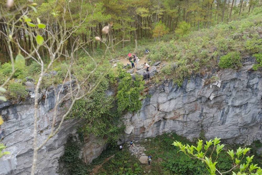 A group of tourists at the mouth of the Meo Vac sinkhole. Photo: Nguyen Duc Manh