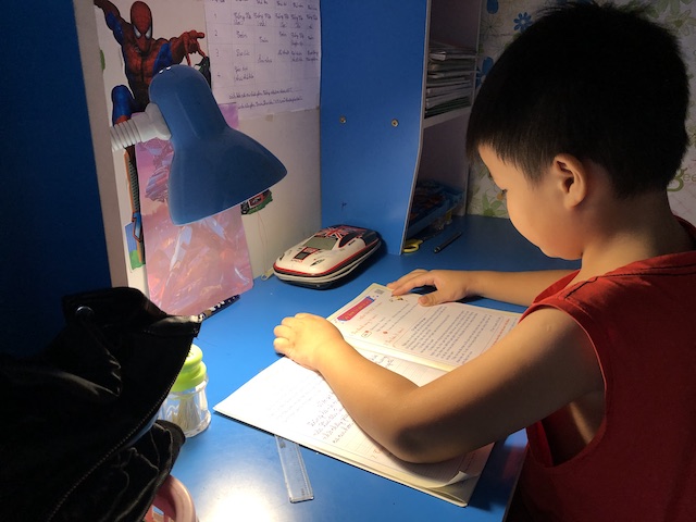  Con công nhân học bài trong khu nhà trọ thuộc xã Kim Chung, huyện Đông Anh, Hà Nội. Ảnh: Quế Chi