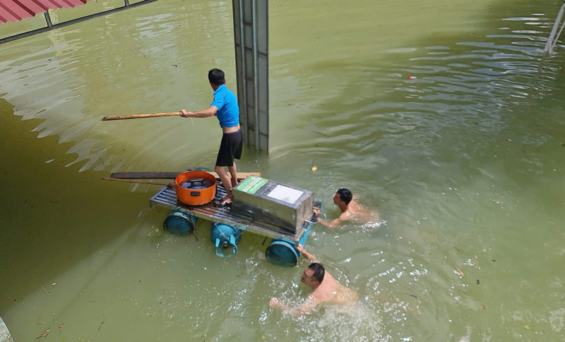 Các thầy giáo đang cố gắng di dời tài sản của nhà trường trên những chiếc bè tự chế. Ảnh: Người dân cung cấp.