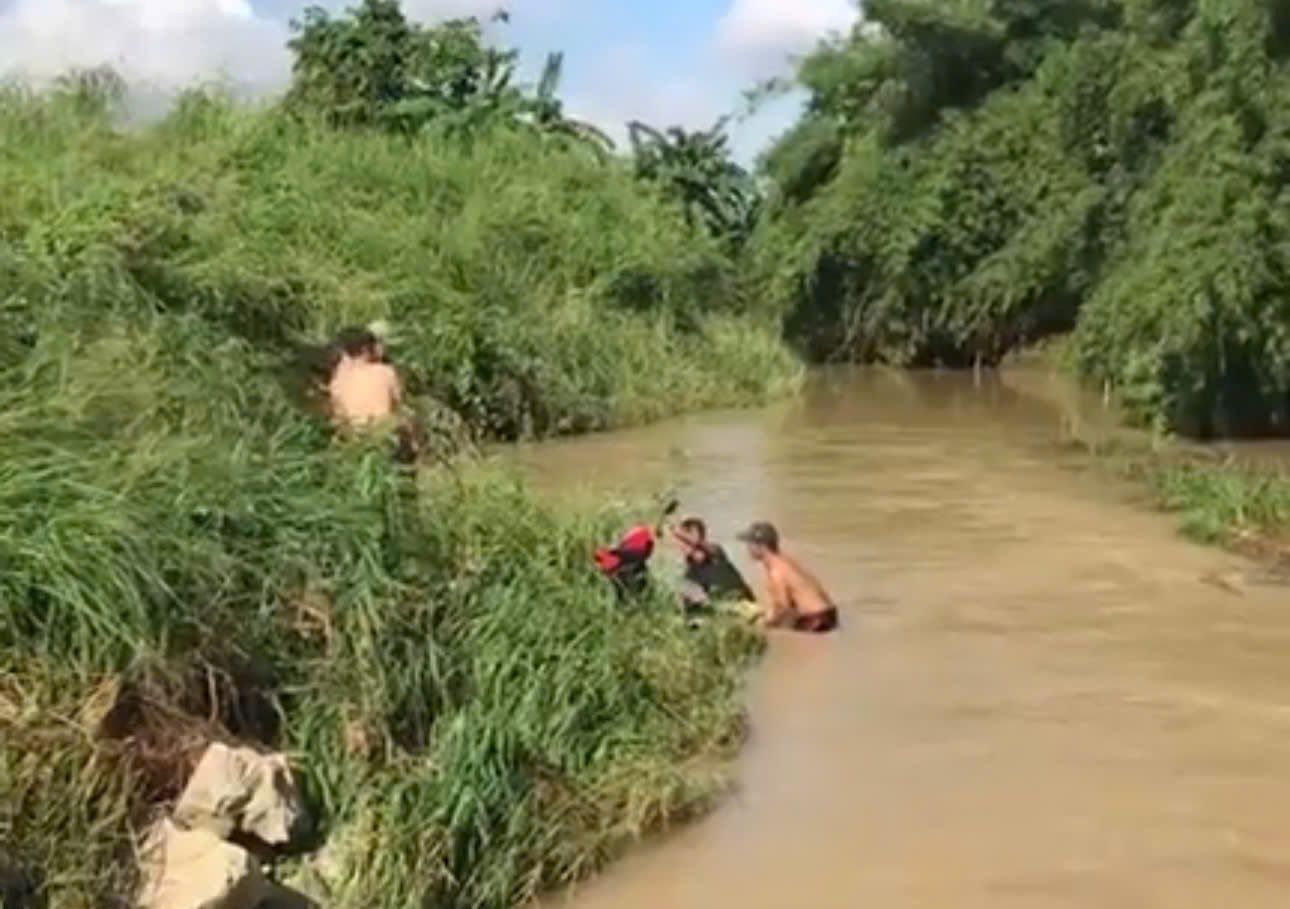 People salvaged motorbikes swept away by water in Tan Lap commune. Photo: NDCC