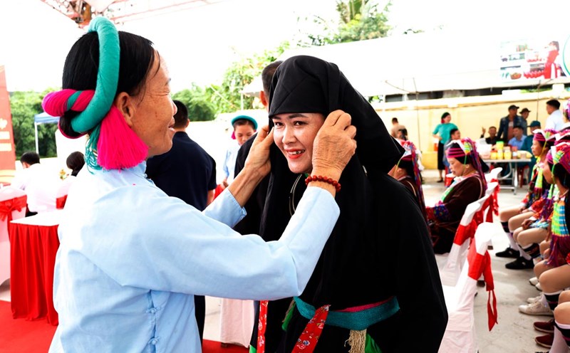 Khách du lịch thử trang phục dân tộc tại phiên chợ Pò Hèn, TP Móng Cái. Ảnh: Cổng TTĐT Móng Cái