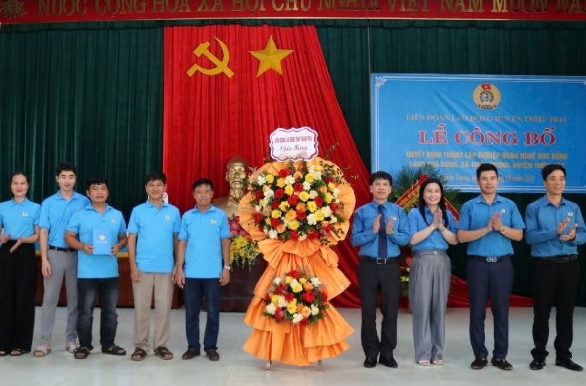 Ông Nguyễn Minh Cảnh - Phó Chủ tịch LĐLĐ và lãnh đạo LĐLĐ tỉnh Thanh Hóa tặng hoa chúc mừng Nghiệp đoàn nghề đúc đồng Trà Đông. Ảnh: Trần Lâm
