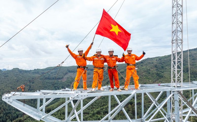 Niềm vui khi hoàn thành xong một vị trí, lá cờ Tổ quốc tung bay trên đỉnh cột đường dây 500kV mạch 3. Ảnh: Thành Vinh