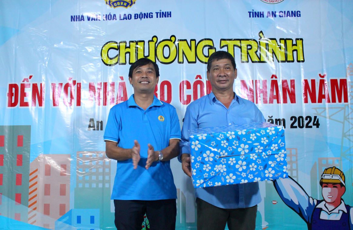 Ông Nguyễn Đức Dục Thanh - Phó Chủ tịch Công đoàn Viên chức tặng 20 bộ áo dài cho đoàn viên, lao động nữ đang sinh sống tại nhà trọ Tú Nga. Ảnh: Lục Tùng