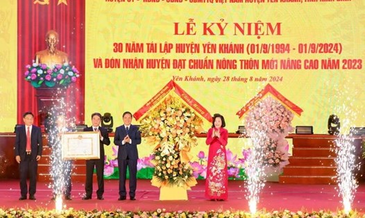 Phó Chủ tịch Quốc hội Nguyễn Thị Thanh trao Bằng công nhận Huyện đạt chuẩn nông thôn mới nâng cao và tặng hoa chúc mừng Đảng bộ, chính quyền và nhân dân huyện Yên Khánh. Ảnh: Nguyễn Trường