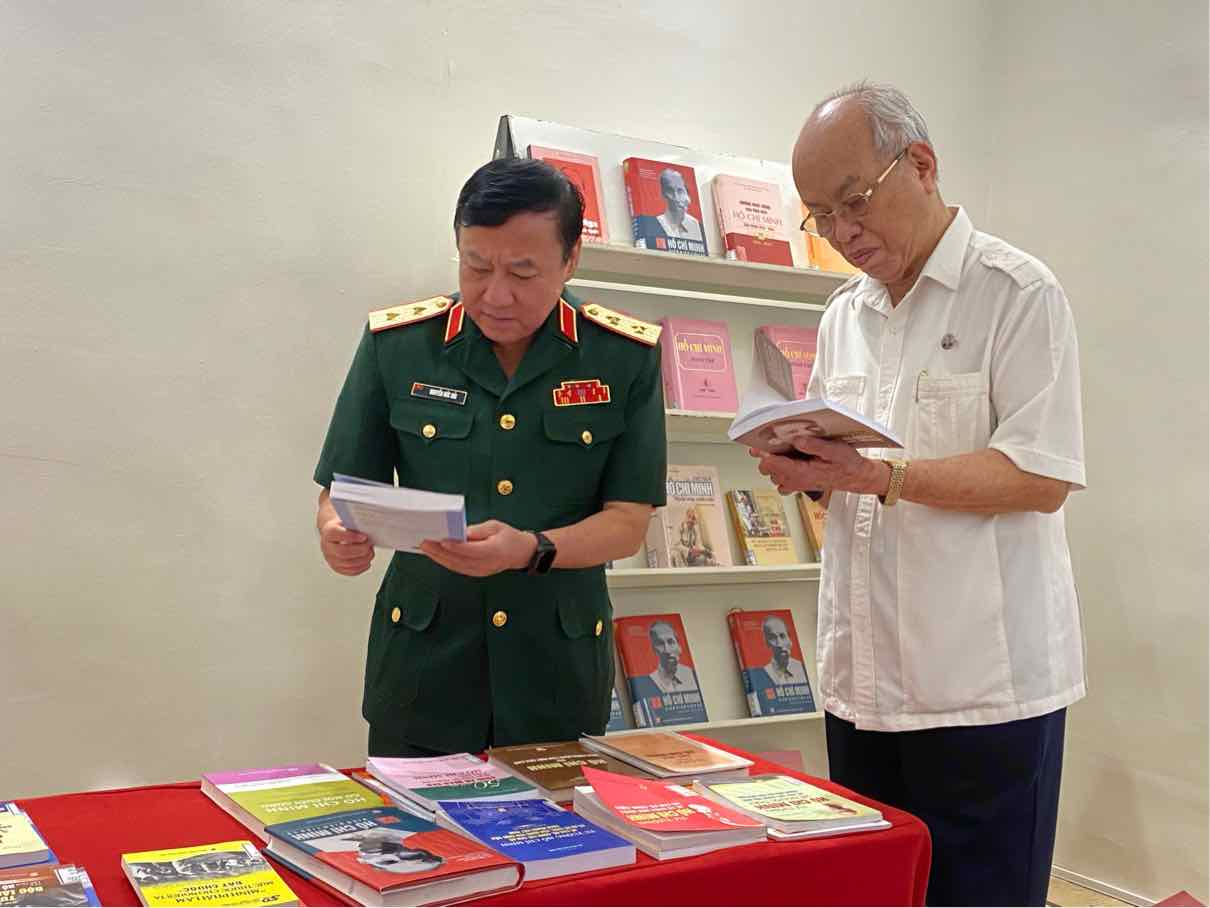 Professor, Dr. Trinh Quang Phu (right) and Lieutenant General Nguyen Duc Hai read books at the exhibition. Photo: La Hue