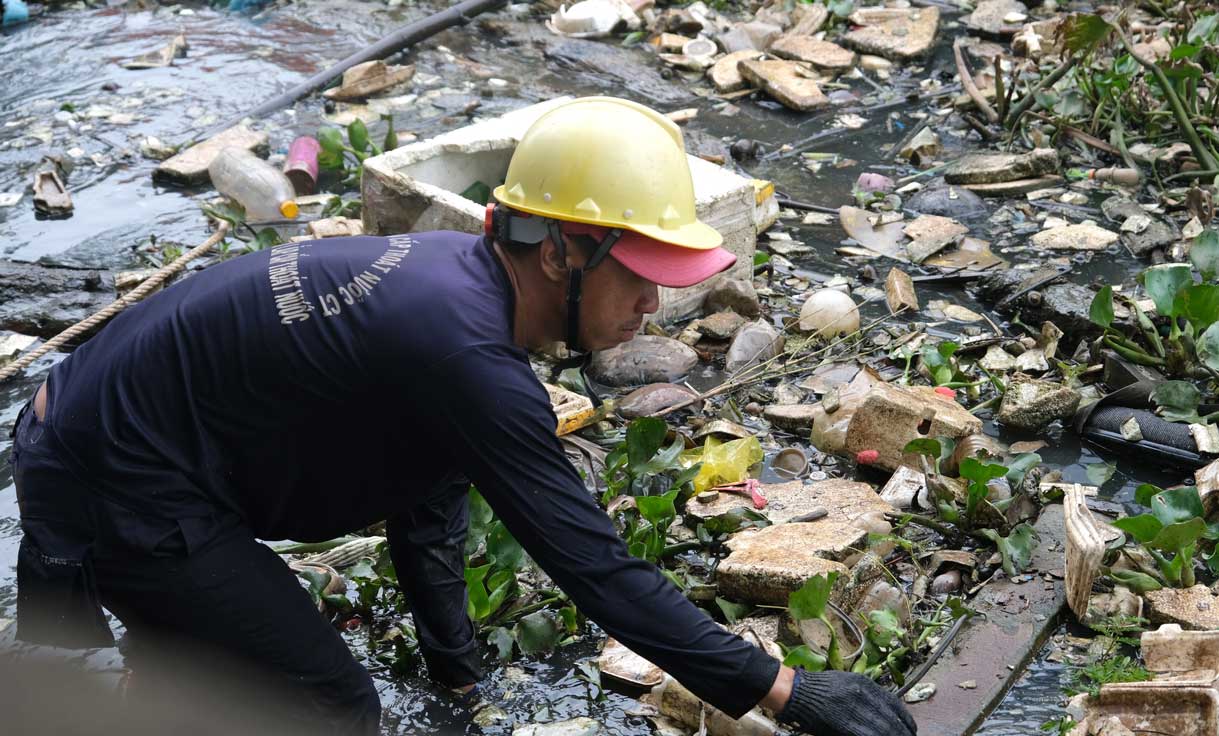 Công nhân thu gom rác dưới rạch Tham Tướng. Ảnh: Phong Linh