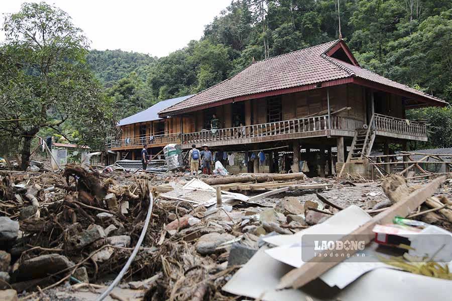 The remaining houses in the middle of the once crowded village are now cluttered with furniture and mud.