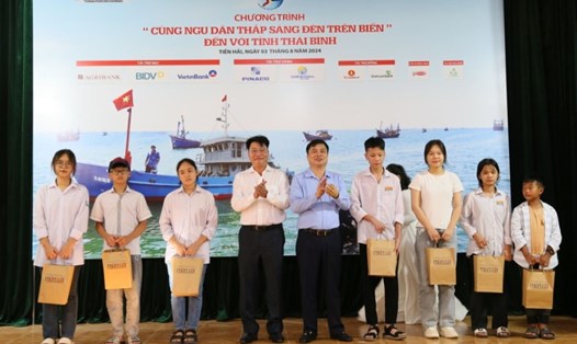 Phó Chủ tịch UBND tỉnh Thái Bình và Phó Tổng Biên tập báo Pháp luật TPHCM trao học bổng cho học sinh là con em ngư dân. Ảnh: Nam Hồng