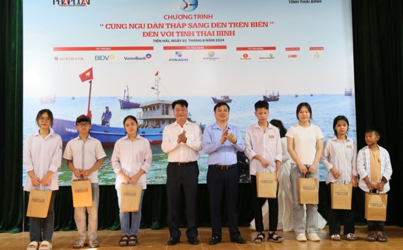 Phó Chủ tịch UBND tỉnh Thái Bình và Phó Tổng Biên tập báo Pháp luật TPHCM trao học bổng cho học sinh là con em ngư dân. Ảnh: Nam Hồng