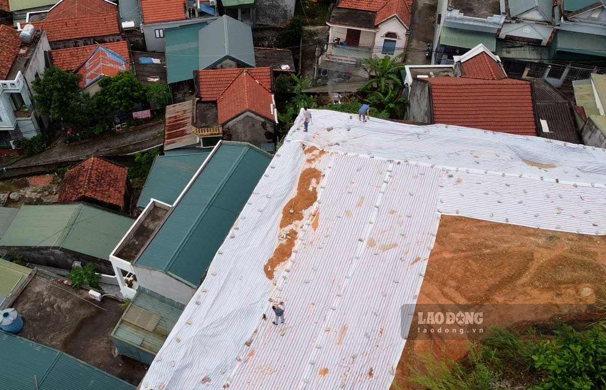 UBND phường Hùng Thắng (Hạ Long, Quảng Ninh) căng bạt chống chống xói lở tại mái kè. Ảnh: Đoàn Hưng