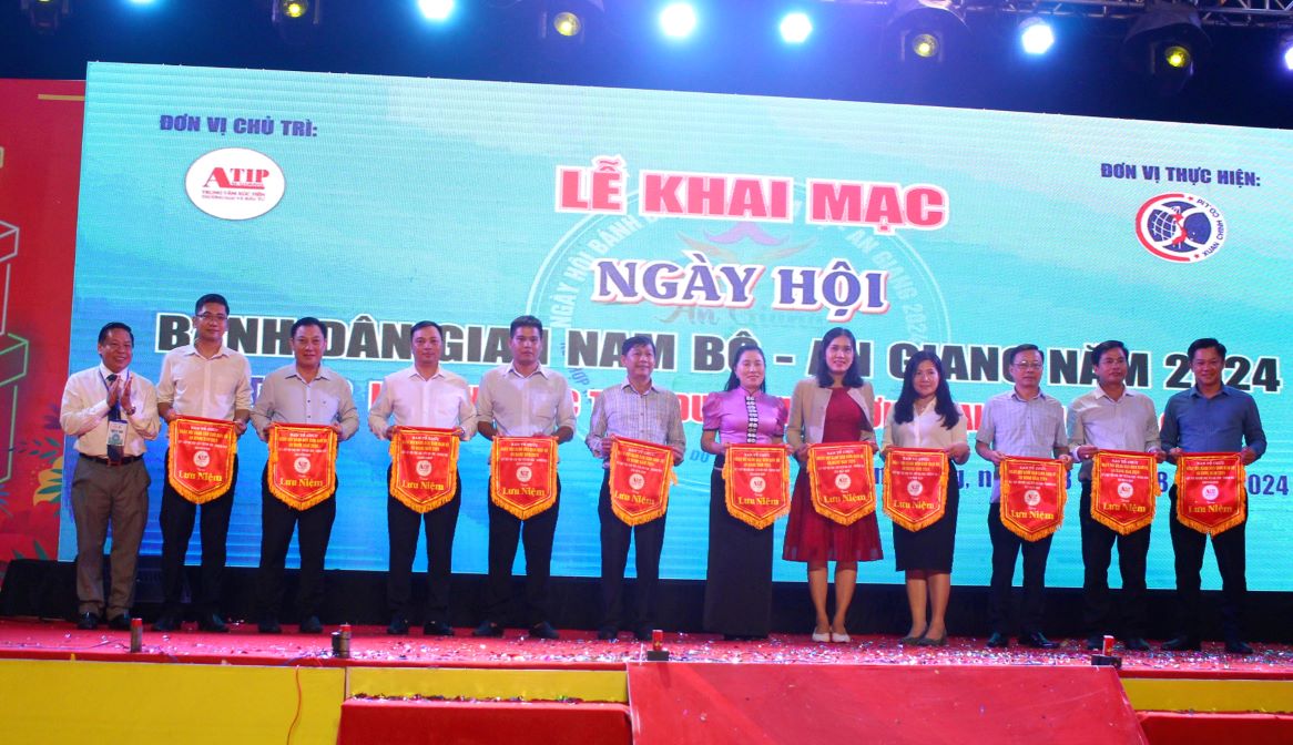 Ông Lê Trung Hiếu- Giám đốc Trung tâm Xúc tiến Thương mại và Đầu tư An Giang tặng cờ lưu niệm cho các đơn vị tham dự, Ảnh: Thanh Mai