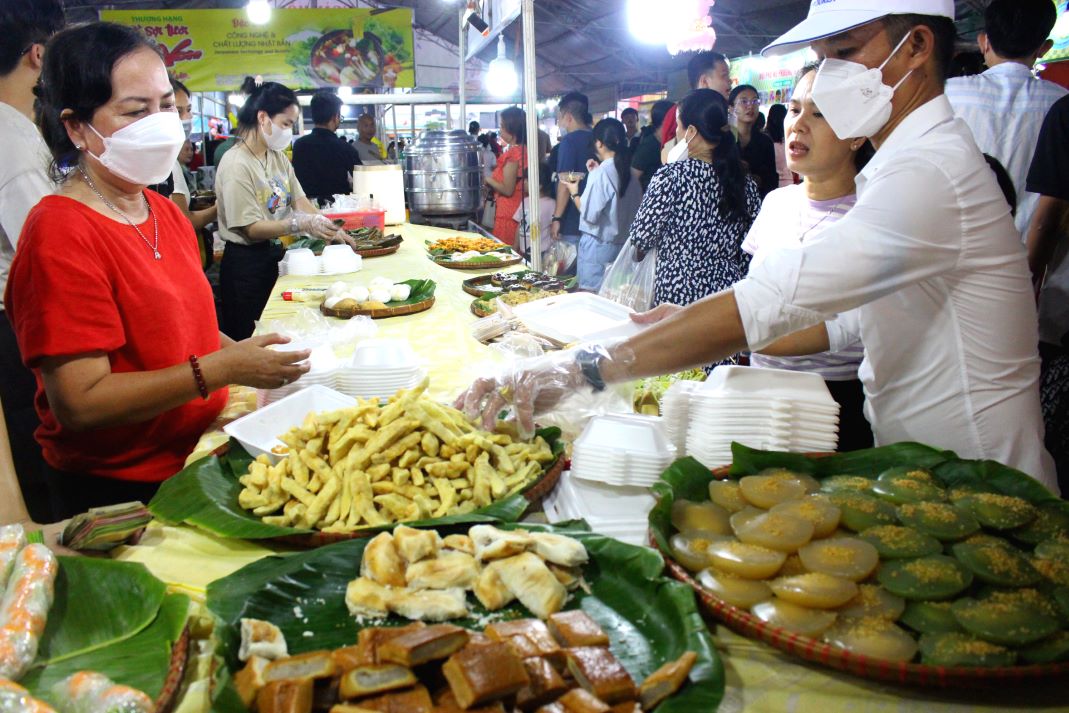 Người tham quan Ngày hội tấp nập mua và thưởng thức bánh dân gian Nam Bộ về nhà làm quà cho người thân. Ảnh: Thanh Mai