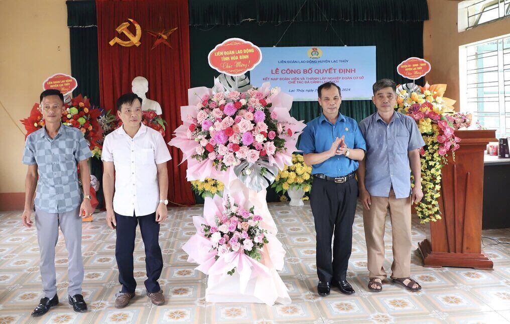 Lãnh đạo LĐLĐ tỉnh Hòa Bình tặng hoa chúc mừng Nghiệp đoàn cơ sở chế tác đá cảnh Lạc Thủy. Ảnh: Phạm Cường