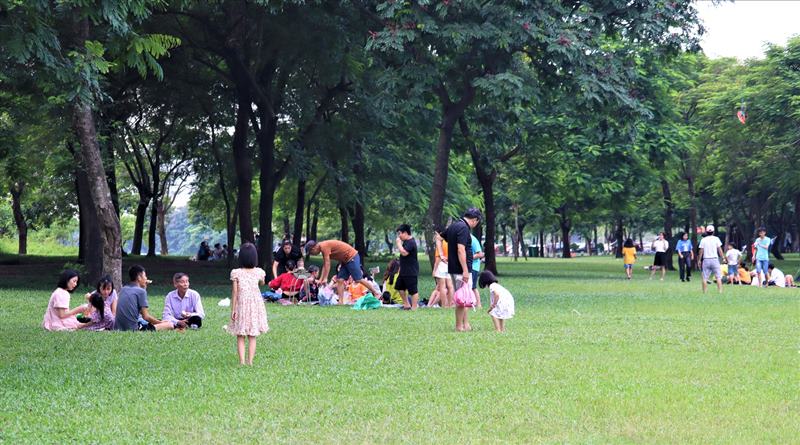 People in the Capital sit on the grass at Yen So Park playing with their families. Photo: Minh Ha