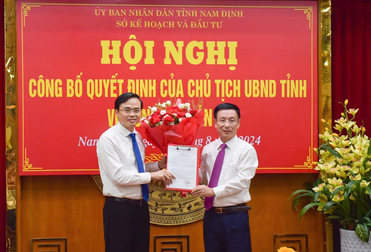 Chủ tịch UBND tỉnh Nam Định Phạm Đình Nghị tặng hoa và trao Quyết định cho Phó Giám đốc Sở Kế hoạch và Đầu tư Phạm Văn Long. Ảnh: Nguyễn Văn