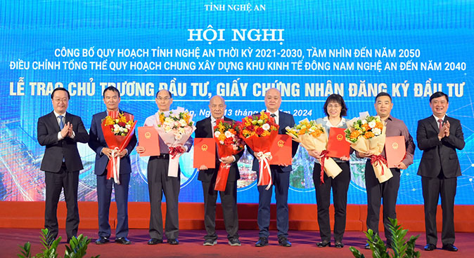 Bí thư Tỉnh ủy Thái Thanh Quý và Chủ tịch UBND tỉnh Nguyễn Đức Trung trao Giấy chứng nhận đầu tư và tặng hoa cho các nhà đầu tư. Ảnh: Anh Tuấn