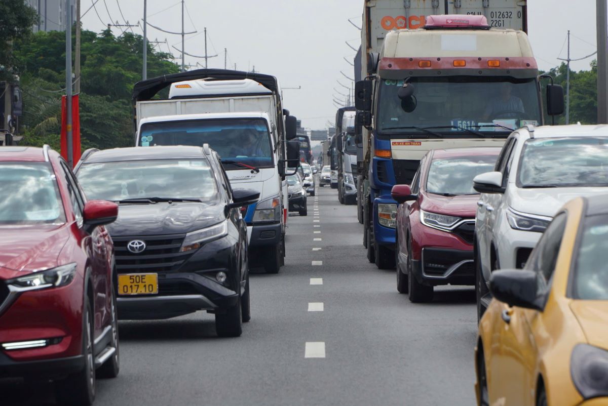 Cars lined up in two long rows, moving slowly to get on the highway.