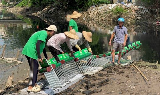 Nhóm tình nguyện Hà Nội xanh đặt phao chắn tại các dòng sông, giúp thu gom rác được thuận tiện hơn. Ảnh: Hoàng Lộc