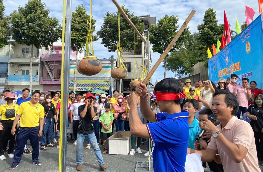 The clay pot smashing game attracts cheers from a large audience. Photo: Vo Dien