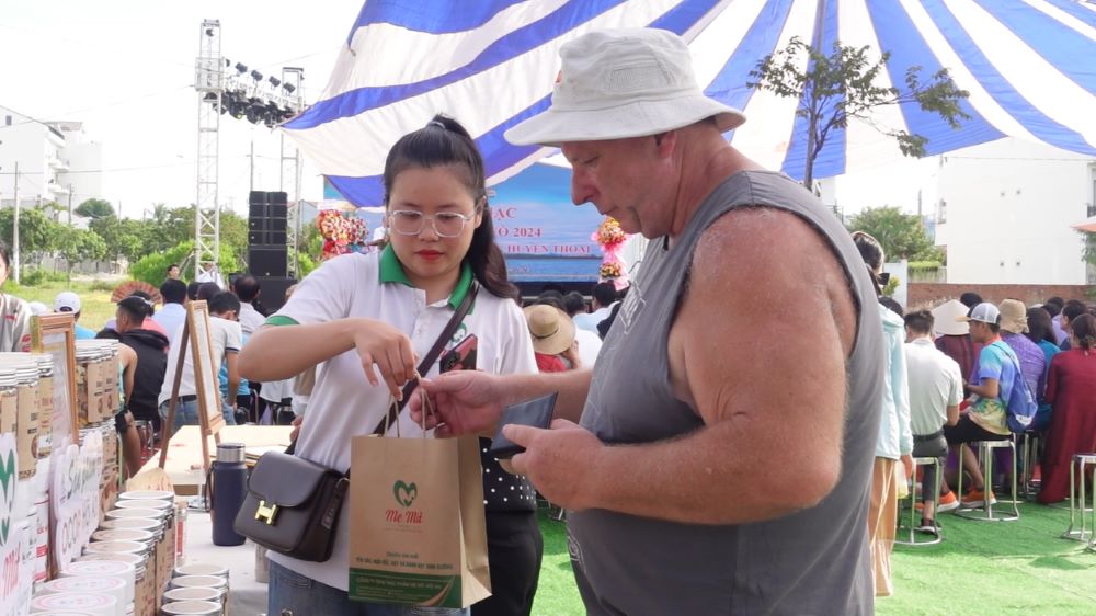 Du khách thích thú với sản phẩm thủ công ở lễ hội Cổ Cò. Ảnh: Trần Thi