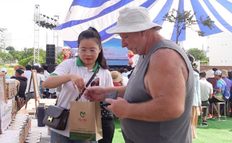 Du khách thích thú với sản phẩm thủ công ở lễ hội Cổ Cò. Ảnh: Trần Thi