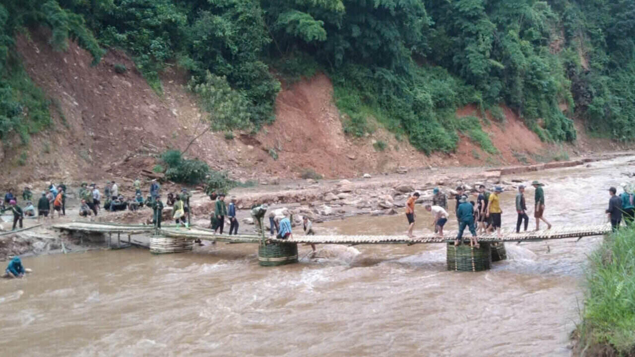 The government, school and people join hands to build a temporary bridge over Ket stream. Photo: Provided by the unit