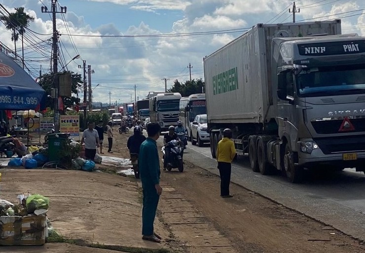 Besides motorbikes and cars, a series of trucks and containers are lined up along a long stretch of National Highway 26. Photo: Bao Trung