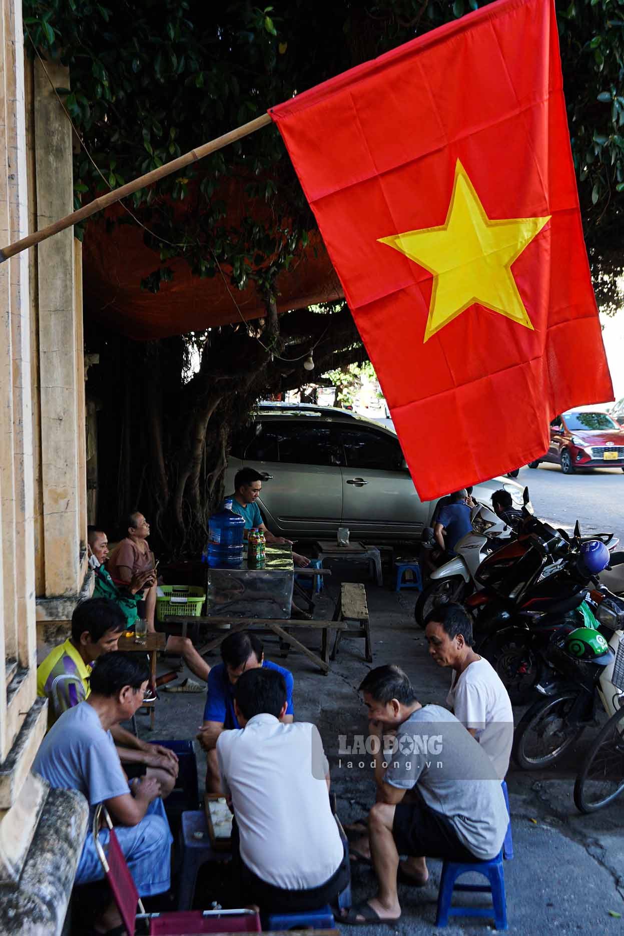 Hanoi people play chess under the red flag with yellow star.