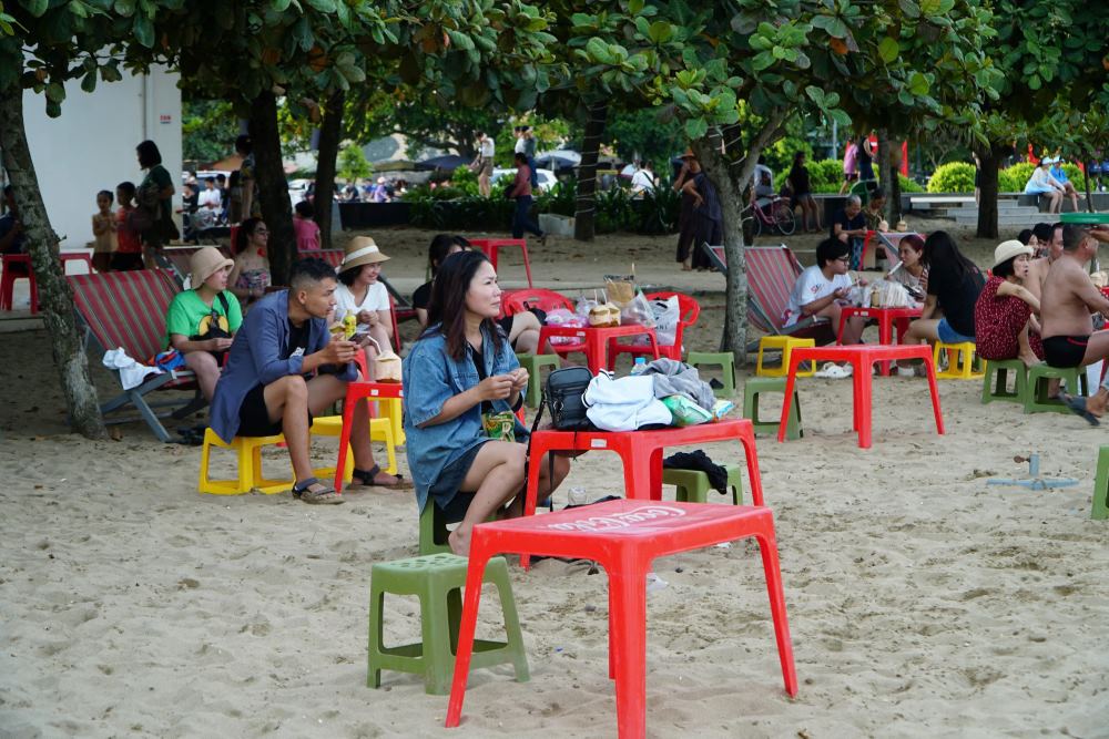 Due to the small number of visitors, there are few people sitting and drinking water on the sandy beach. Photo: Quach Du