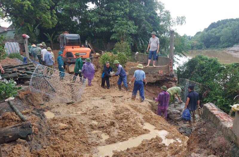 Officials and people participating in temporary embankment to prevent erosion of the left bank of the Ngan Mo River in Cam Due Commune during the 2023 flood season. Photo: Tran Tuan.