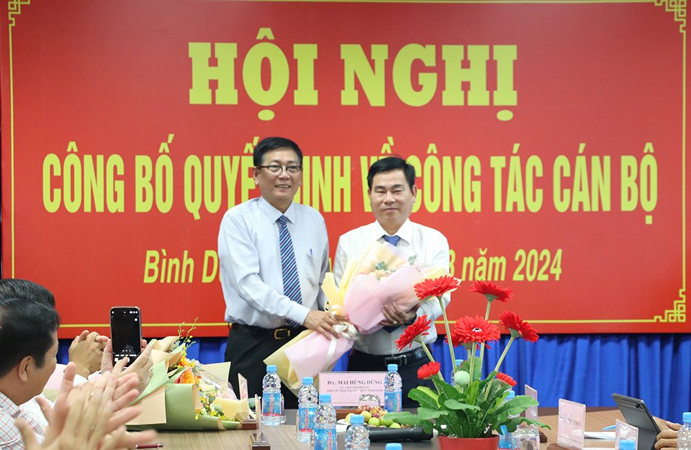 Ông Mai Hùng Dũng - Phó Chủ tịch Thường trực UBND tỉnh tặng hoa cảm ơn những đóng góp của ông Nguyễn Văn Minh trong thời gian làm Giám đốc Sở Nội vụ​. Ông Võ Văn Minh về làm Bí thư Thành ủy thành phố Thuận An. Ảnh: UBND Bình Dương