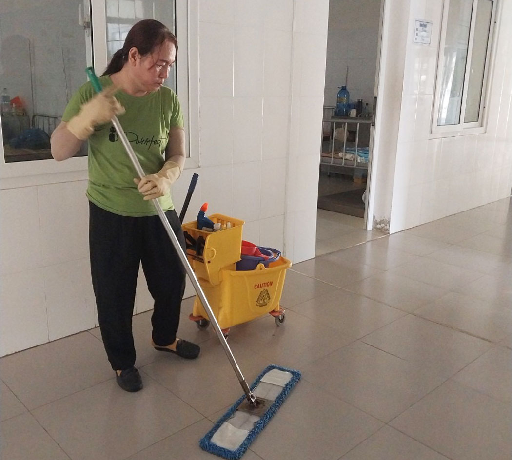 Chị Võ Thị Bích Thủy với công việc tạp vụ tạm bợ tại một cơ quan. Ảnh: Xuân Nhàn.