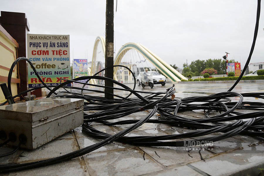 Trên vỉa hè khu vực cầu Thanh Bình, các loại dây cáp ngổn ngang tiềm ẩn mất an toàn giao thông cho người đi bộ.