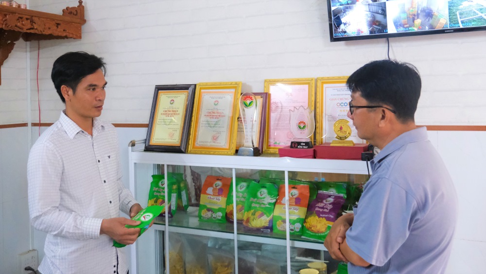 Anh Nguyễn Chương Phi (bìa trái) ở huyện Cao Lãnh, tỉnh Đồng Tháp giới thiệu sản phẩm đang sản xuất tại cơ sở sau khoảng thời gian làm việc ở nước ngoài. Ảnh: Phong Linh.