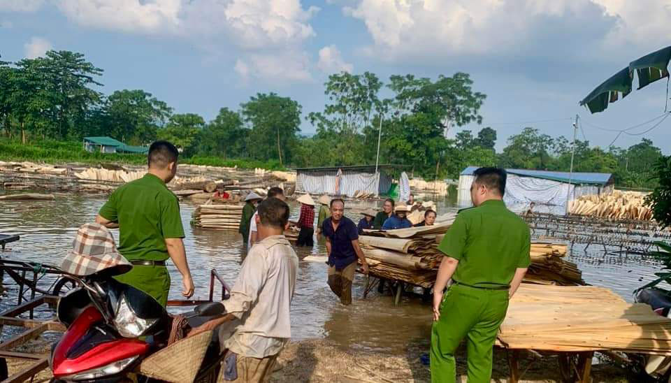 Lực lượng dân quân cơ động giúp người dân di chuyển đồ đạc ra khỏi khu vực nước ngập. Ảnh: NDCC