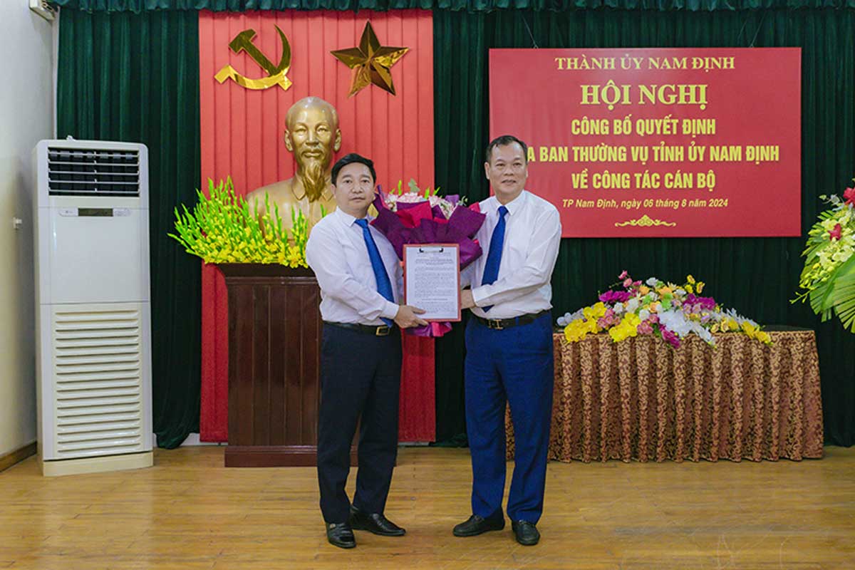 Phó Bí thư Thường trực Tỉnh ủy Nam Định Lê Quốc Chỉnh trao quyết định, tặng hoa chúc mừng ông Nguyễn Tiến Dũng - Phó Bí thư Thành ủy Nam Định. Ảnh: Phan Nam - Cổng TTĐT TP.Nam Định