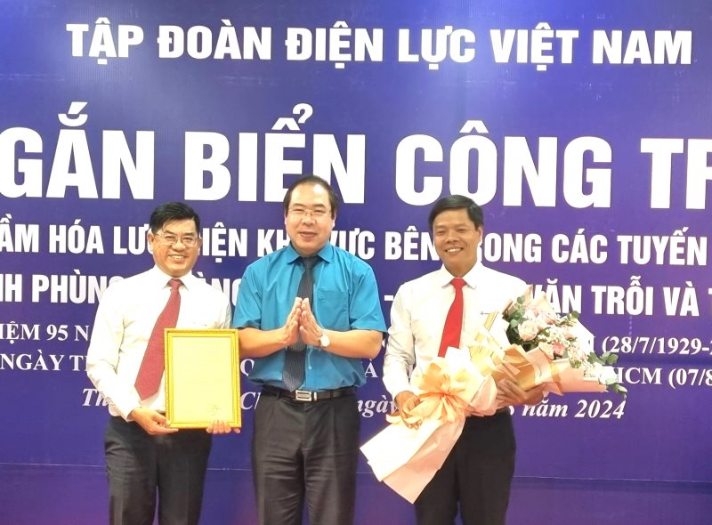 Mr. Do Duc Hung - Chairman of the Vietnam Electricity Trade Union (in the middle) - awards the decision to commend and presents flowers to the leaders and trade union of EVNHCMC. Photo: Nam Duong