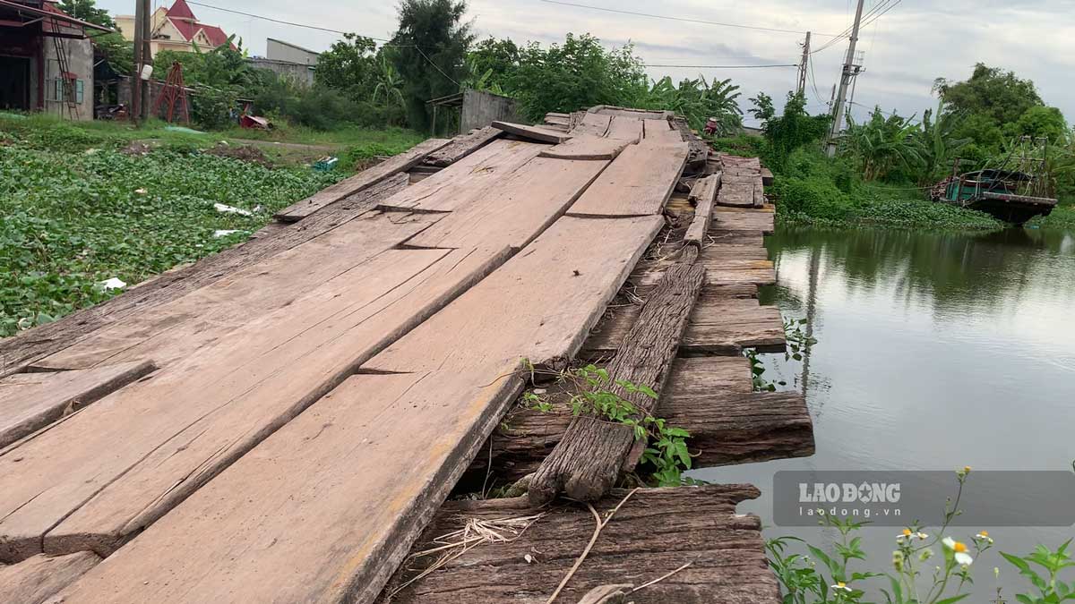 Mặt cầu xuống cấp được "vá" tạm thời bằng miếng ván quan tài sau cải táng. Ảnh: Lương Hà