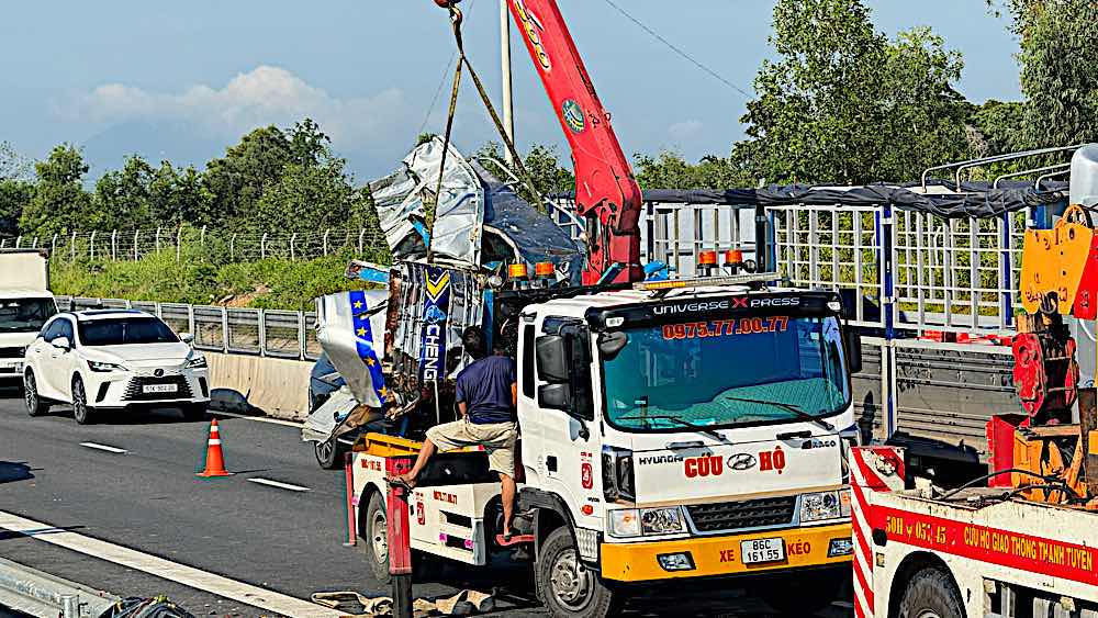 A crane was used to lift the damaged cabin of the truck, which was stuck on the trailer's cargo compartment. Photo: Duy Tuấn 