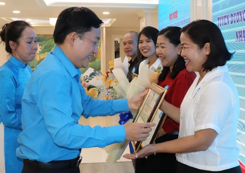 Mr. Phùng Thái Quang - Vice Chairman of the Ho Chi Minh City Labor Union - presents the Certificate of Merit of the Ho Chi Minh City Labor Union to journalists. Photo: Nam Dương