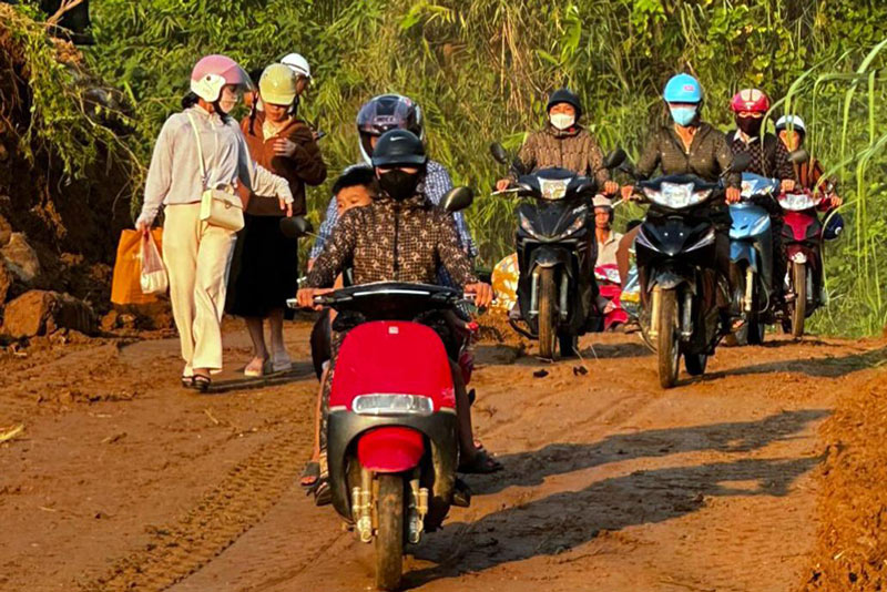 Trong lúc chờ khắc phục sạt lở trên Quốc lộ 279 Lào Cai, người dân tạm thời di chuyển qua đường tránh được mở. Ảnh: Tùng Lâm