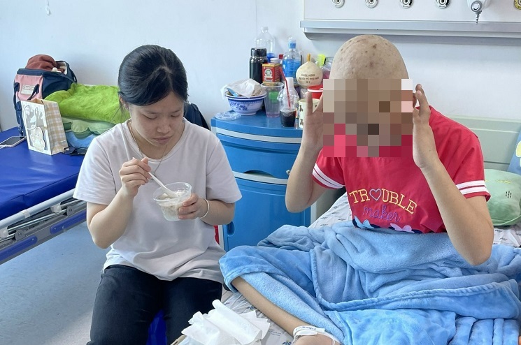 Family members taking care of Vy during her days in the hospital. Photo: Ba Trung
